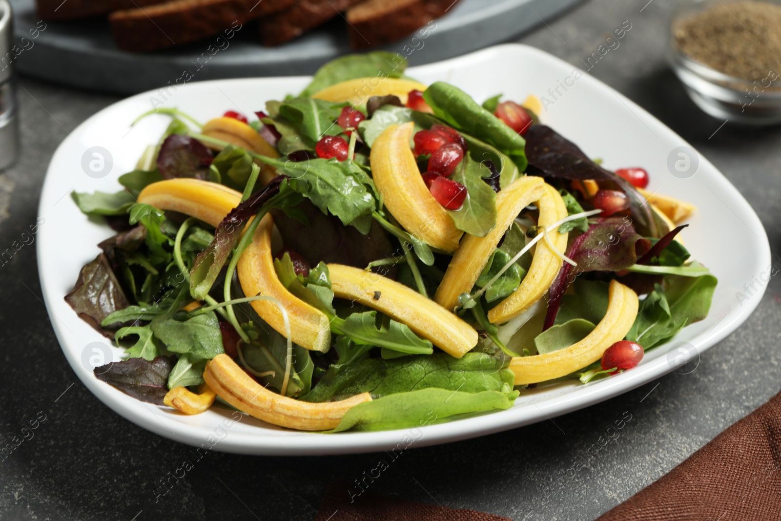 Photo of Delicious fresh carrot salad served on grey table, closeup