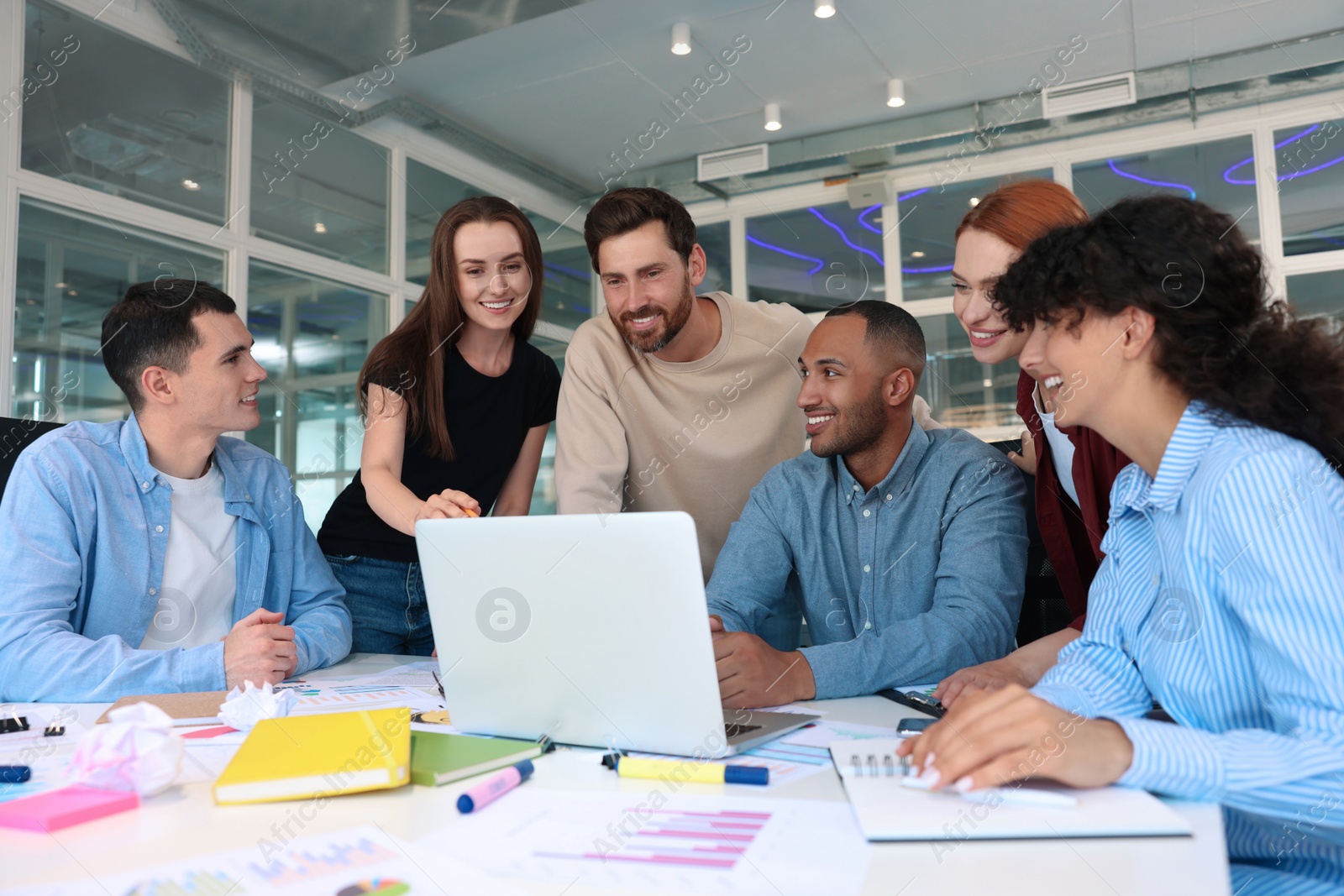 Photo of Team of employees working together at table in office. Startup project