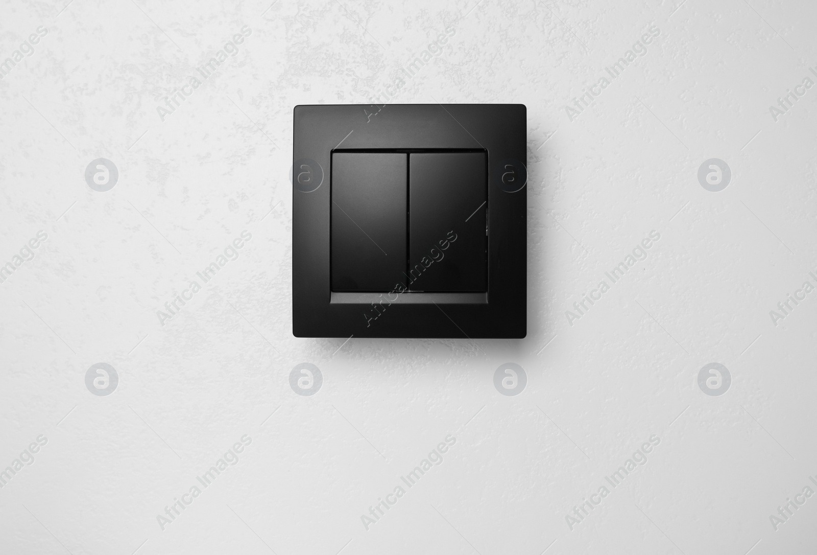 Photo of Black plastic light switch on white background