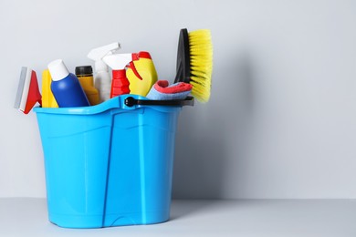 Photo of Different car products in bucket near white wall, space for text