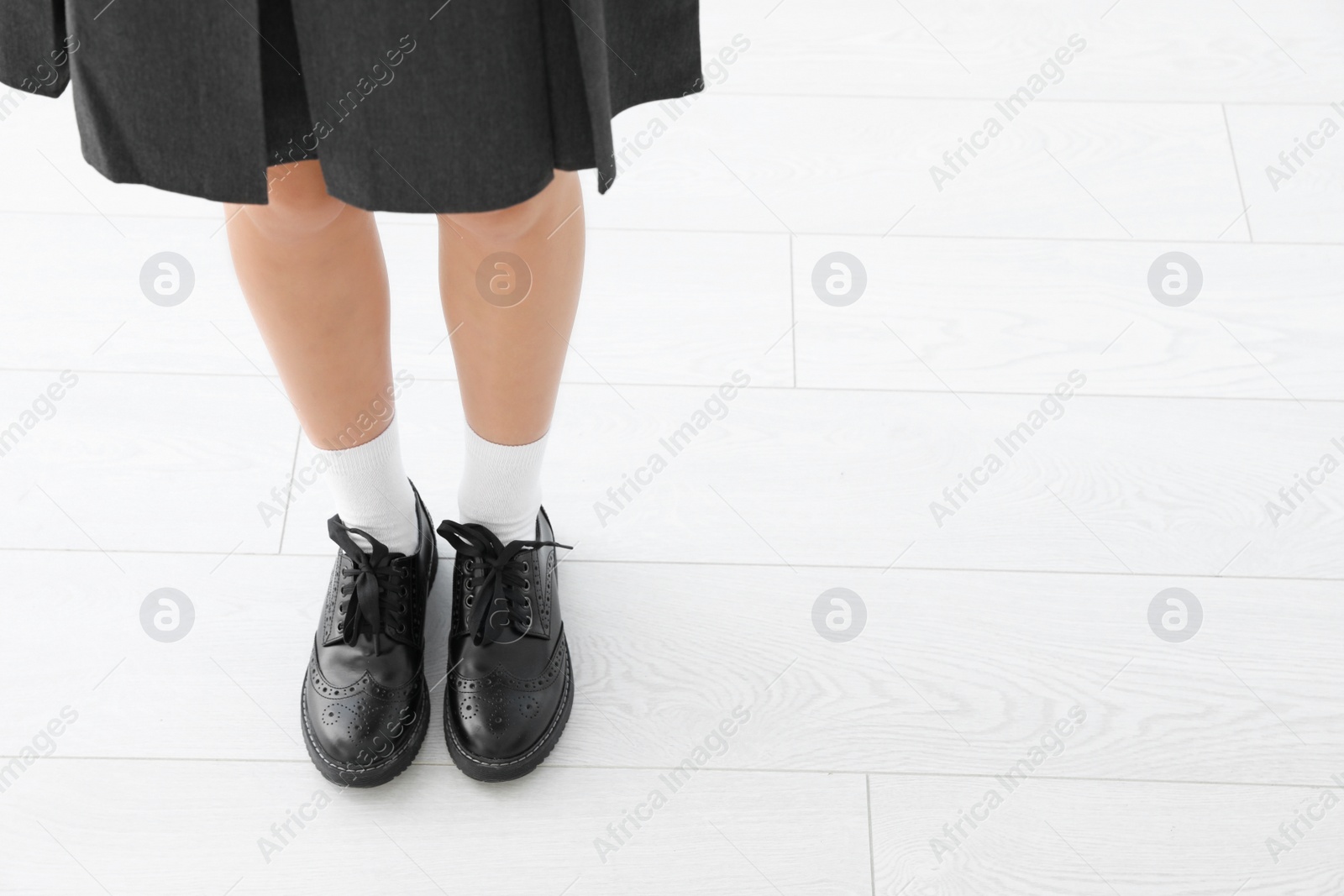 Photo of Girl in stylish school uniform indoors, focus on legs