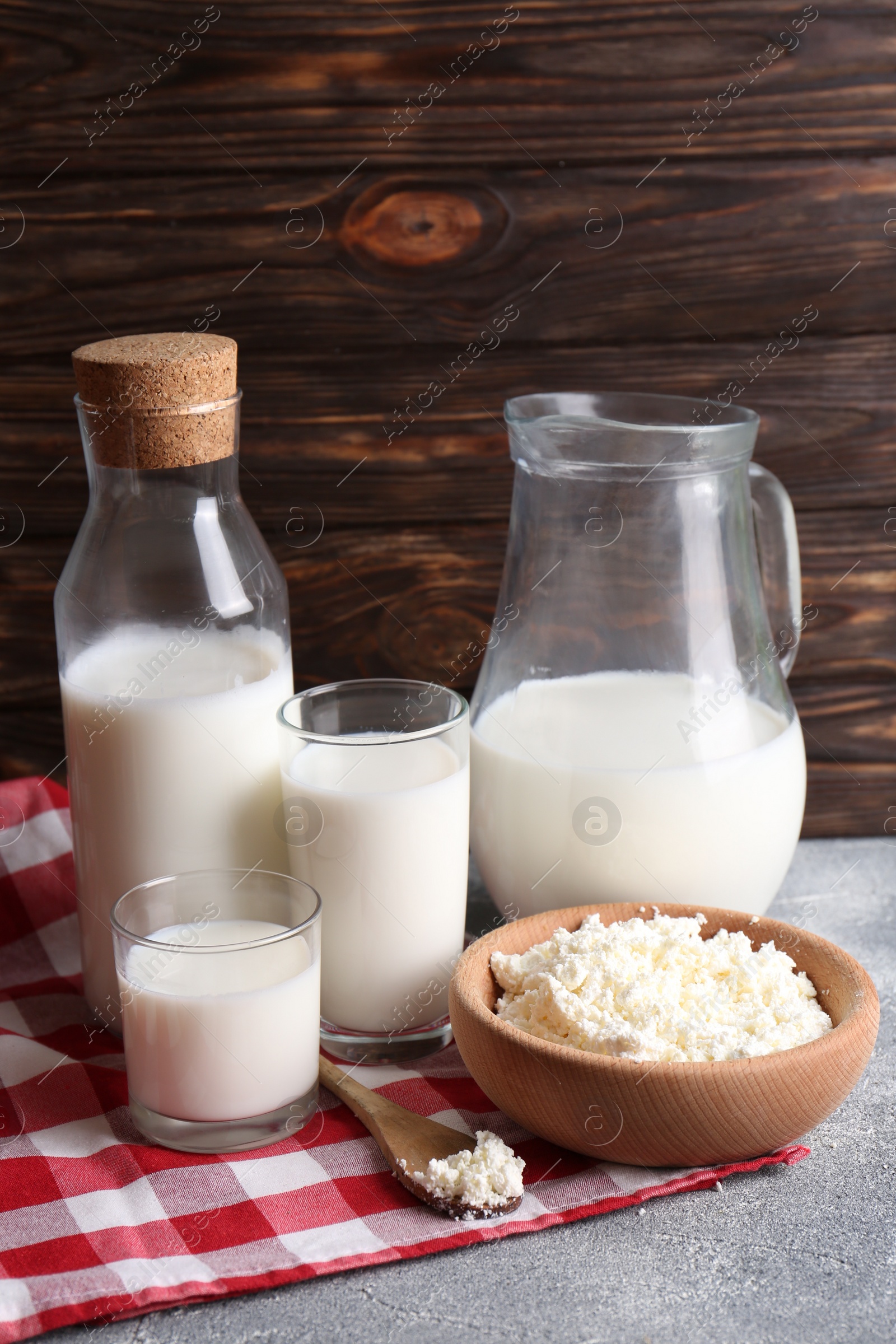 Photo of Tasty fresh milk and cottage cheese on grey table