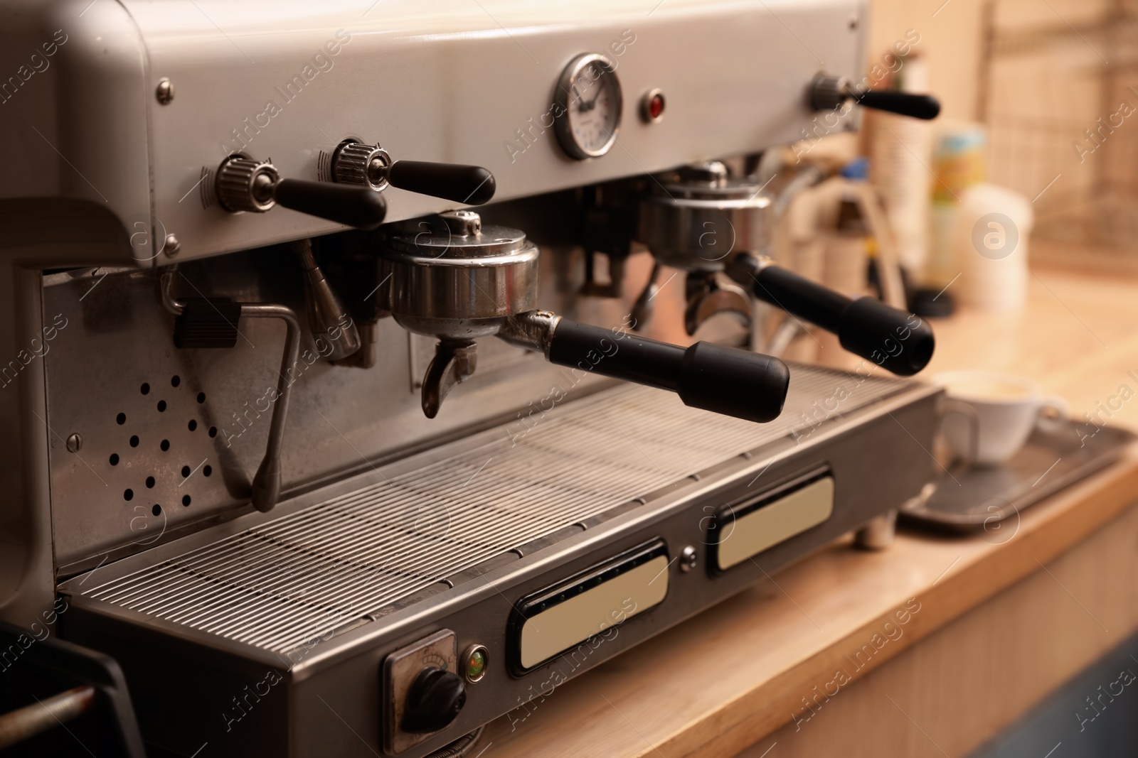 Photo of Modern electric coffee machine with portafilters on table