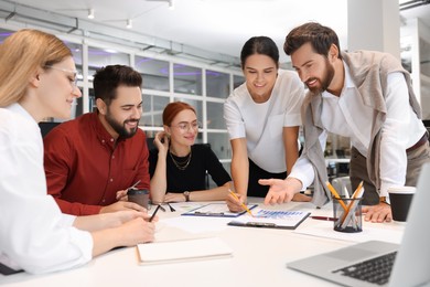 Photo of Team of employees working together in office