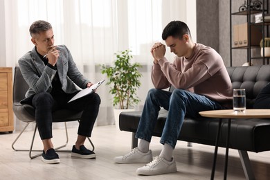 Photo of Professional psychotherapist working with patient in office