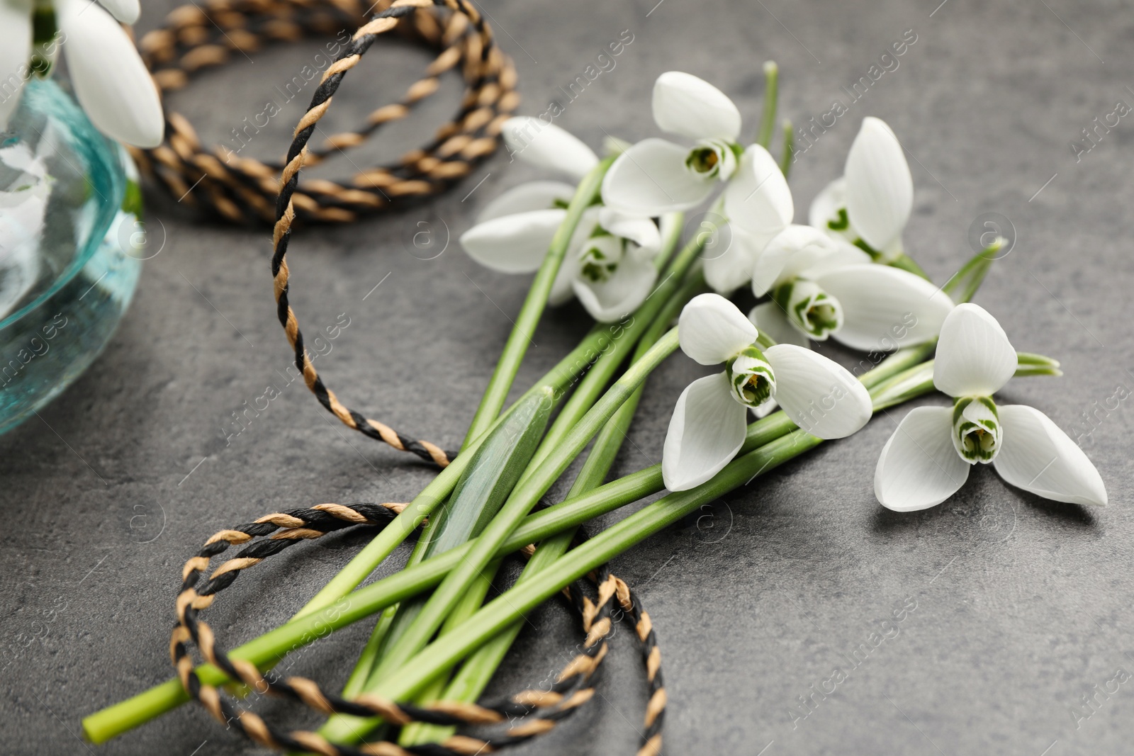 Photo of Beautiful snowdrops and twine on grey table. Spring flowers