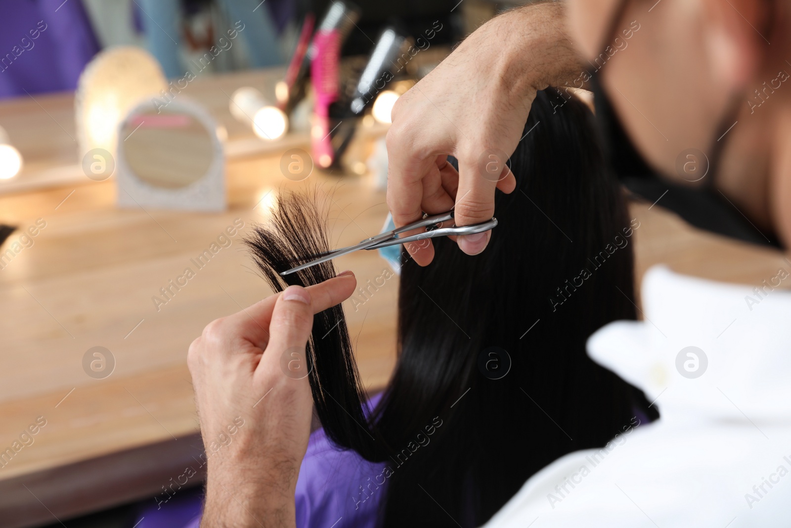 Photo of Professional stylist working with client in salon, closeup. Hairdressing services during Coronavirus quarantine