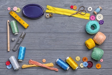 Photo of Flat lay composition with sewing threads and accessories on wooden background