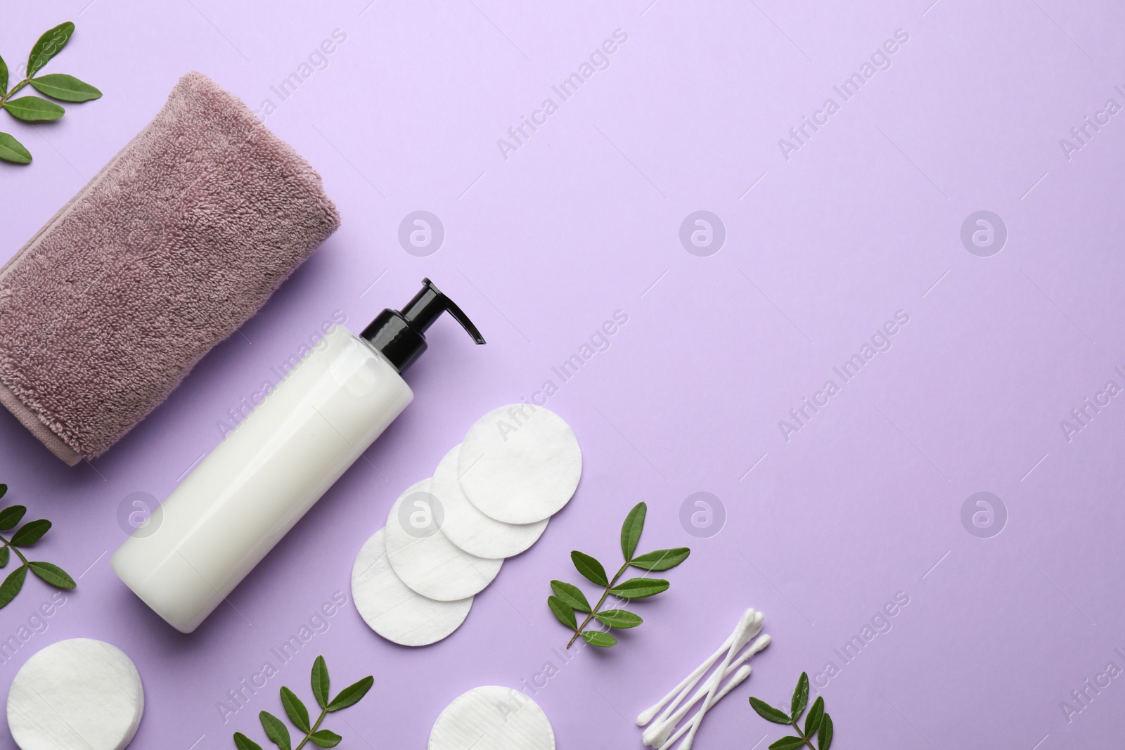 Photo of Cotton pads, swabs, towel and makeup removal product on violet background, flat lay. Space for text