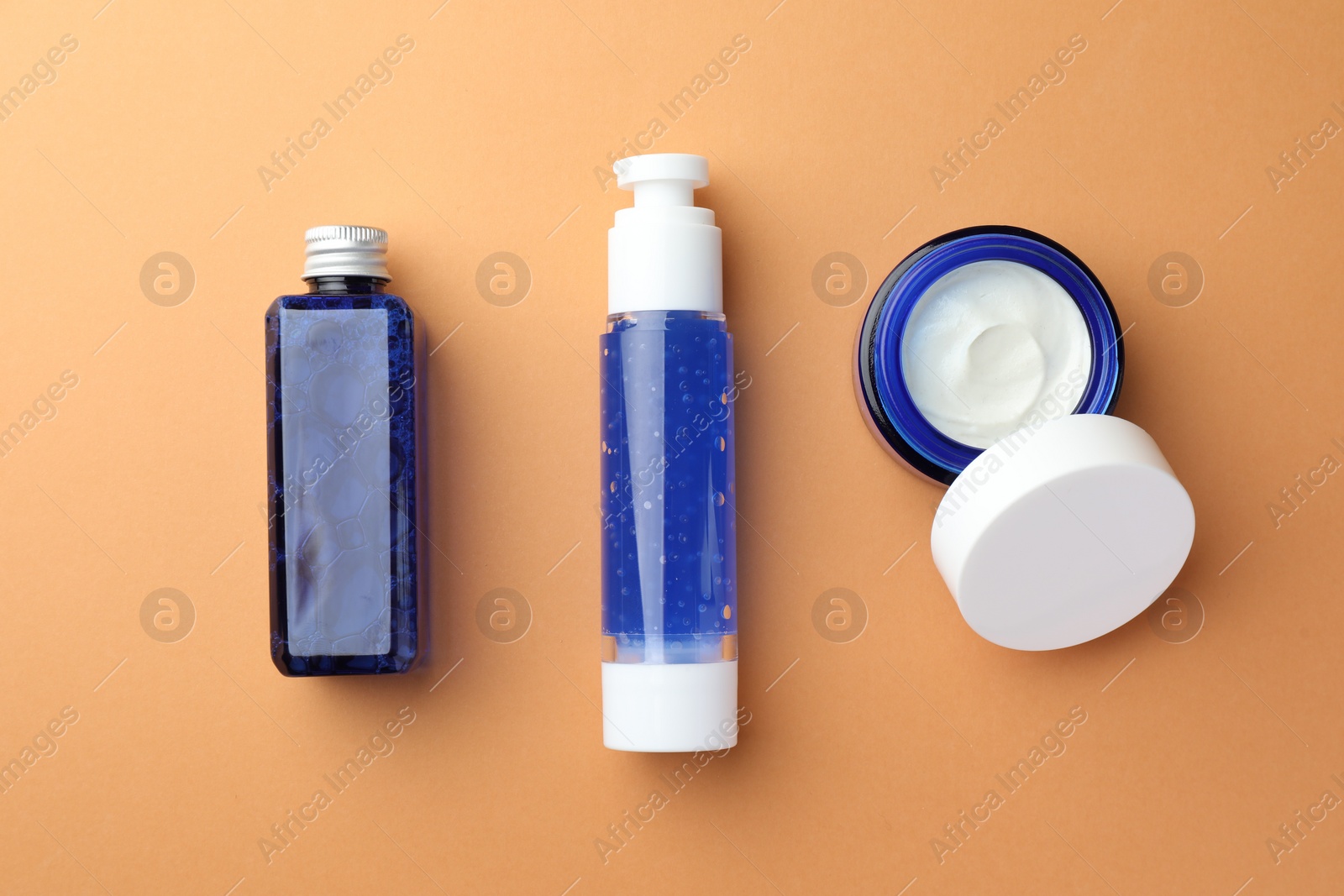 Photo of Set of cosmetic products on orange background, flat lay