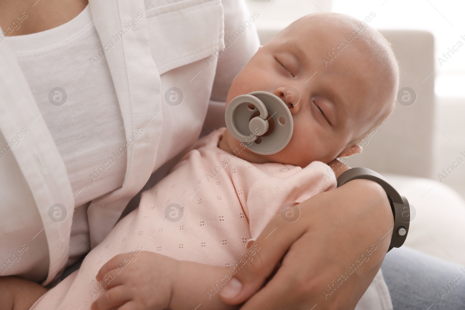 Photo of Mother with her cute sleeping baby at home, closeup