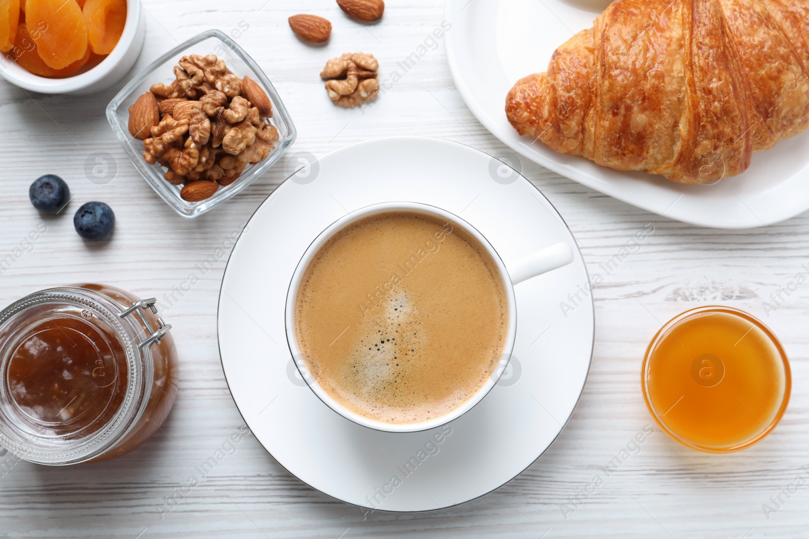 Photo of Delicious breakfast with cup of coffee on white wooden table, flat lay