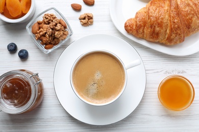 Delicious breakfast with cup of coffee on white wooden table, flat lay