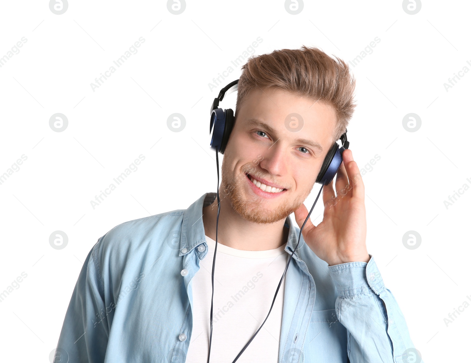 Photo of Handsome young man listening to music with headphones on white background