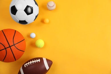 Photo of Many different sports balls on yellow background, flat lay. Space for text