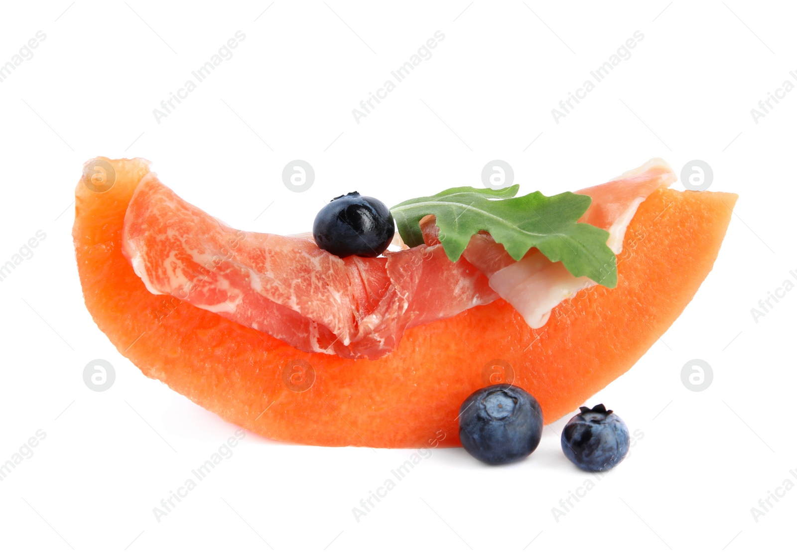 Photo of Slice of fresh melon with prosciutto, blueberries and arugula on white background