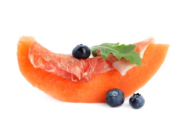 Photo of Slice of fresh melon with prosciutto, blueberries and arugula on white background