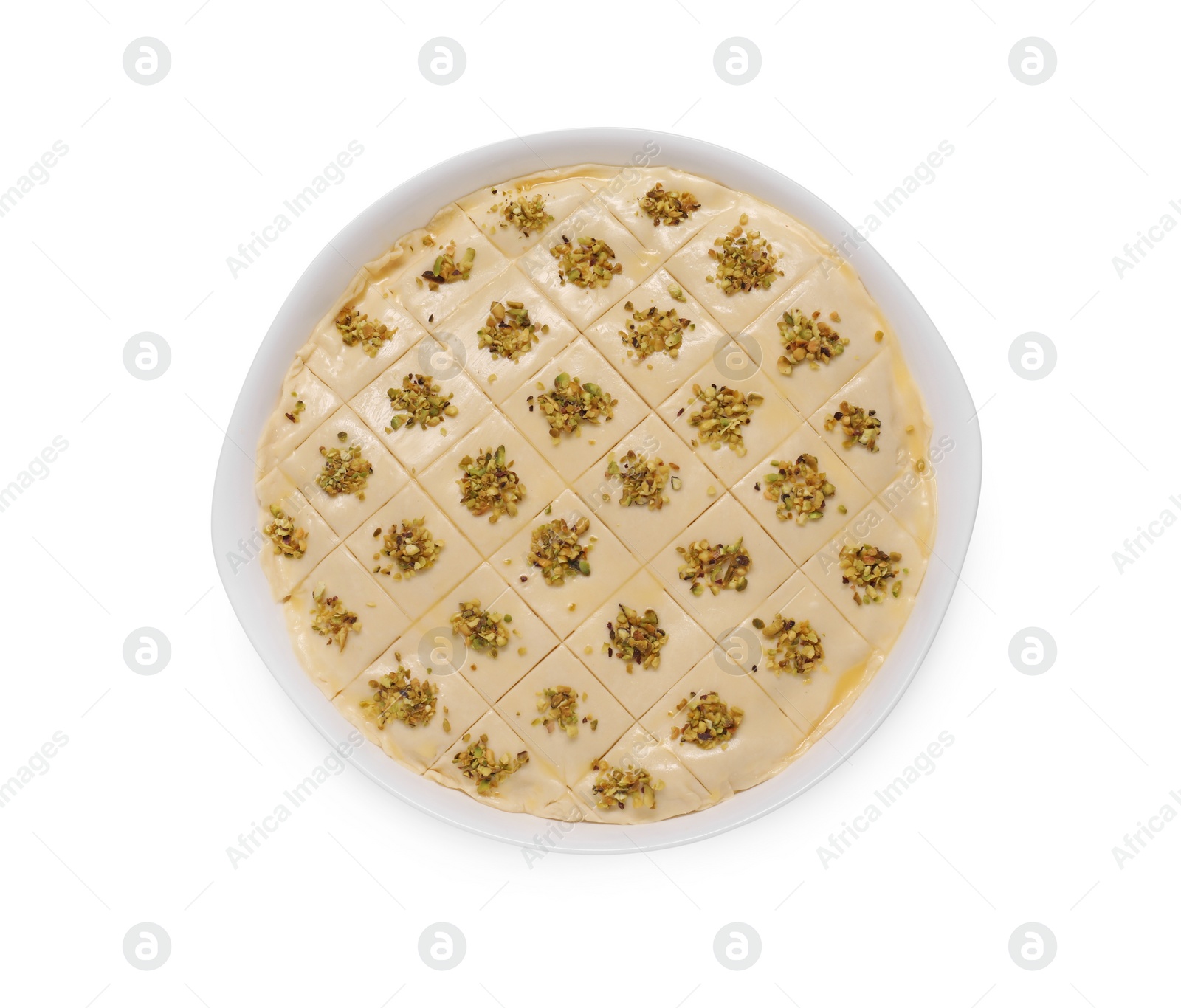 Photo of Making delicious baklava. Raw dough with pistachios in dish isolated on white, top view