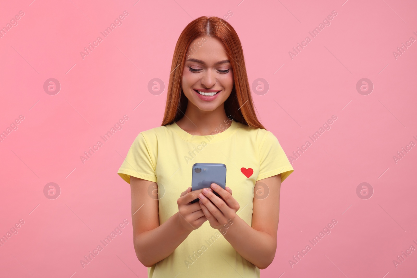 Photo of Beautiful happy woman using smartphone on pink background