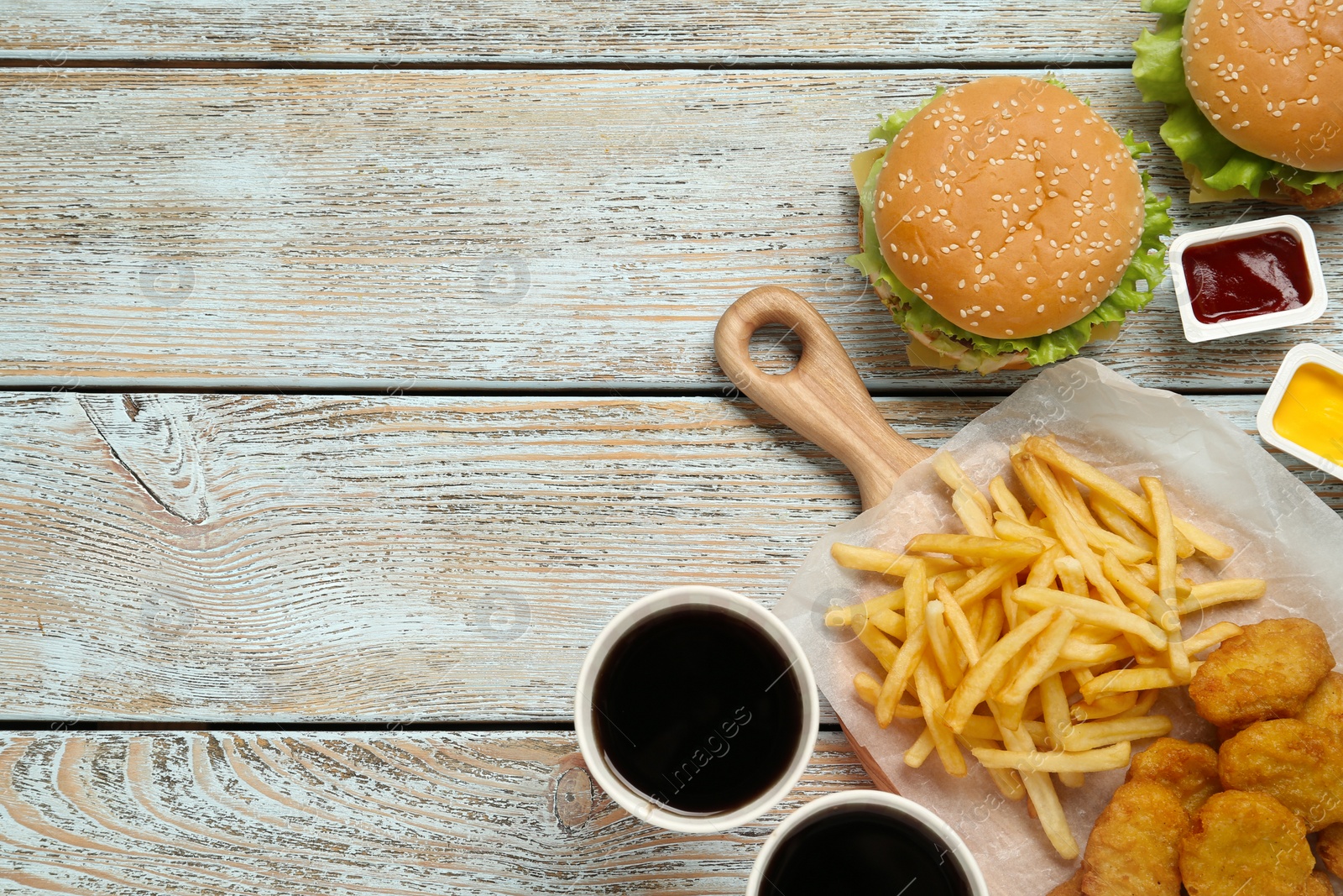 Photo of Flat lay composition with delicious fast food menu on white wooden table. Space for text