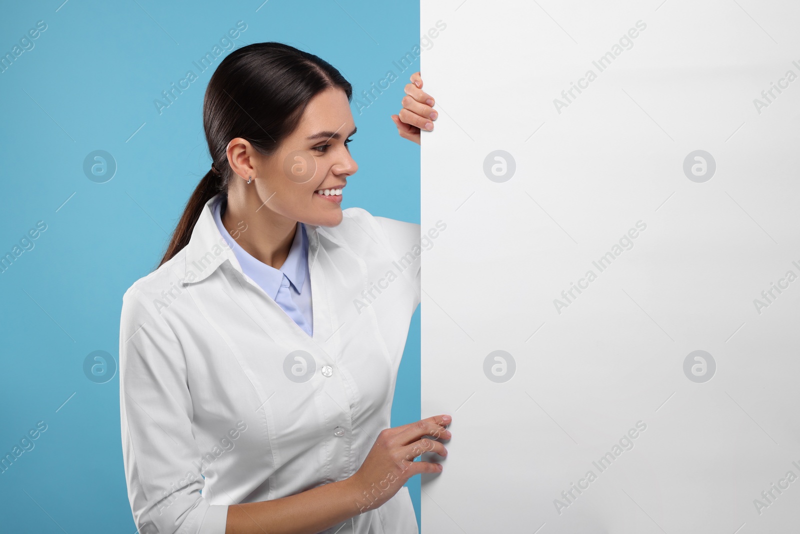 Photo of Ophthalmologist with blank banner on light blue background, space for text