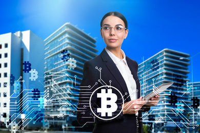 Fintech concept. Scheme with bitcoin symbols and businesswoman using tablet on cityscape background