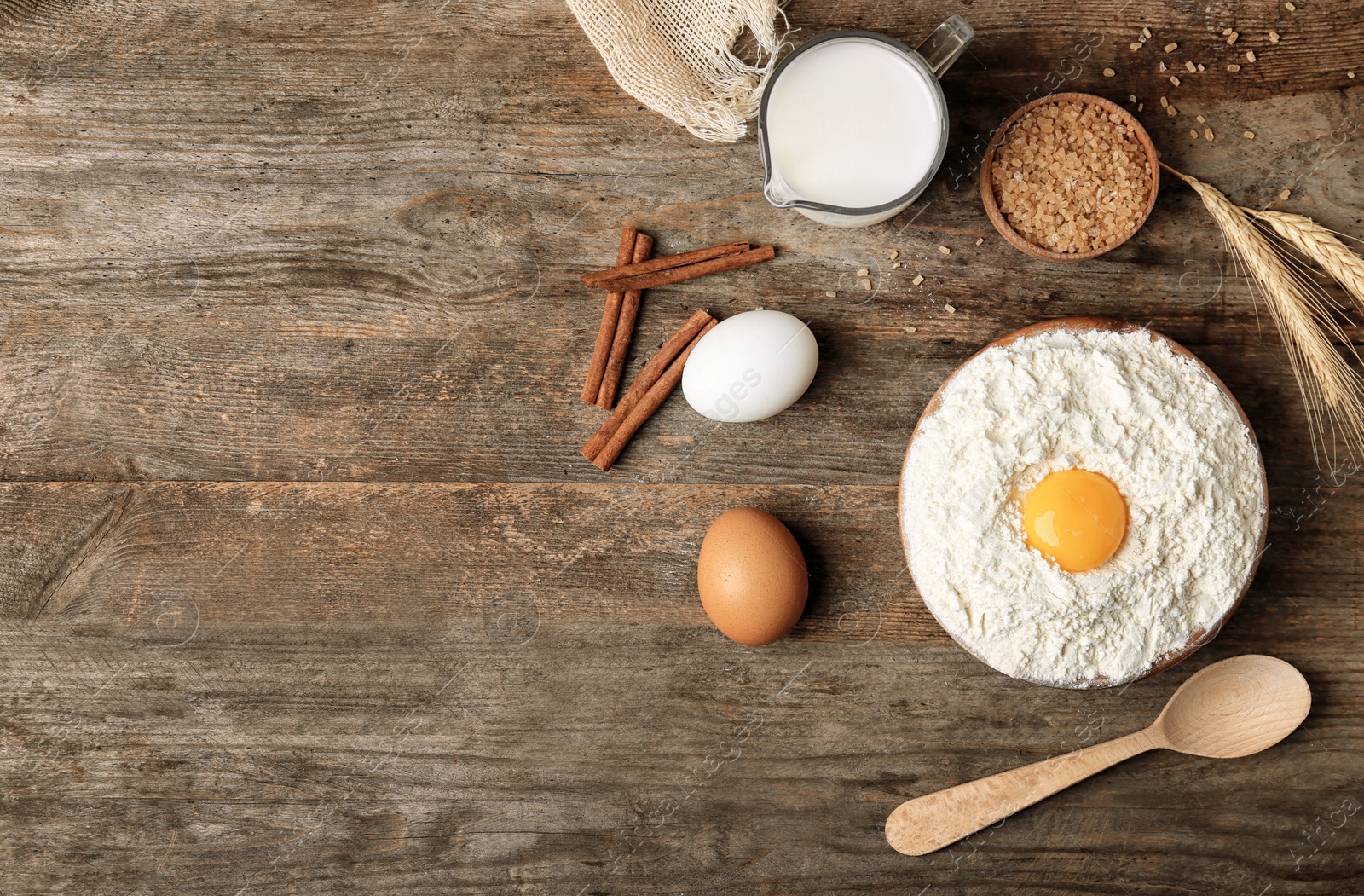 Photo of Composition with flour, eggs and sugar on wooden background, top view