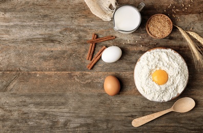 Photo of Composition with flour, eggs and sugar on wooden background, top view