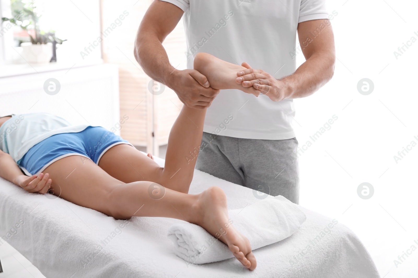 Photo of Young woman receiving massage in salon, closeup