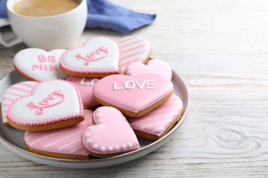 Photo of Decorated heart shaped cookies on white wooden table, space for text. Valentine's day treat