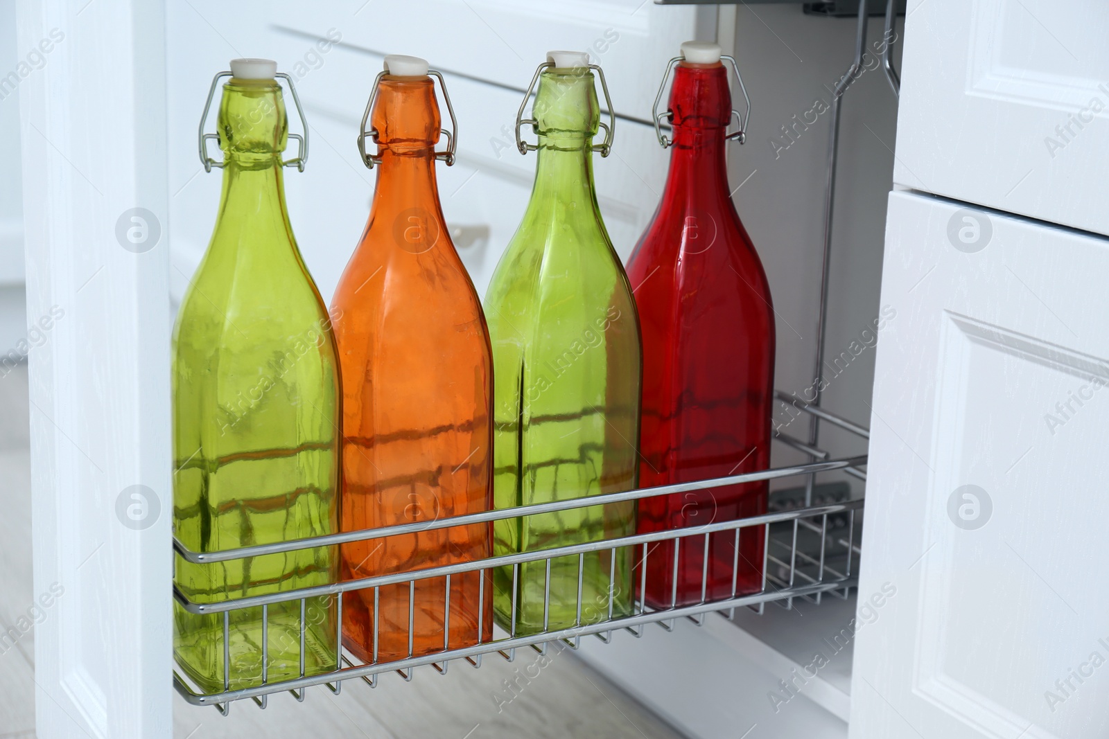 Photo of Shelf with different bottles indoors. Order in kitchen