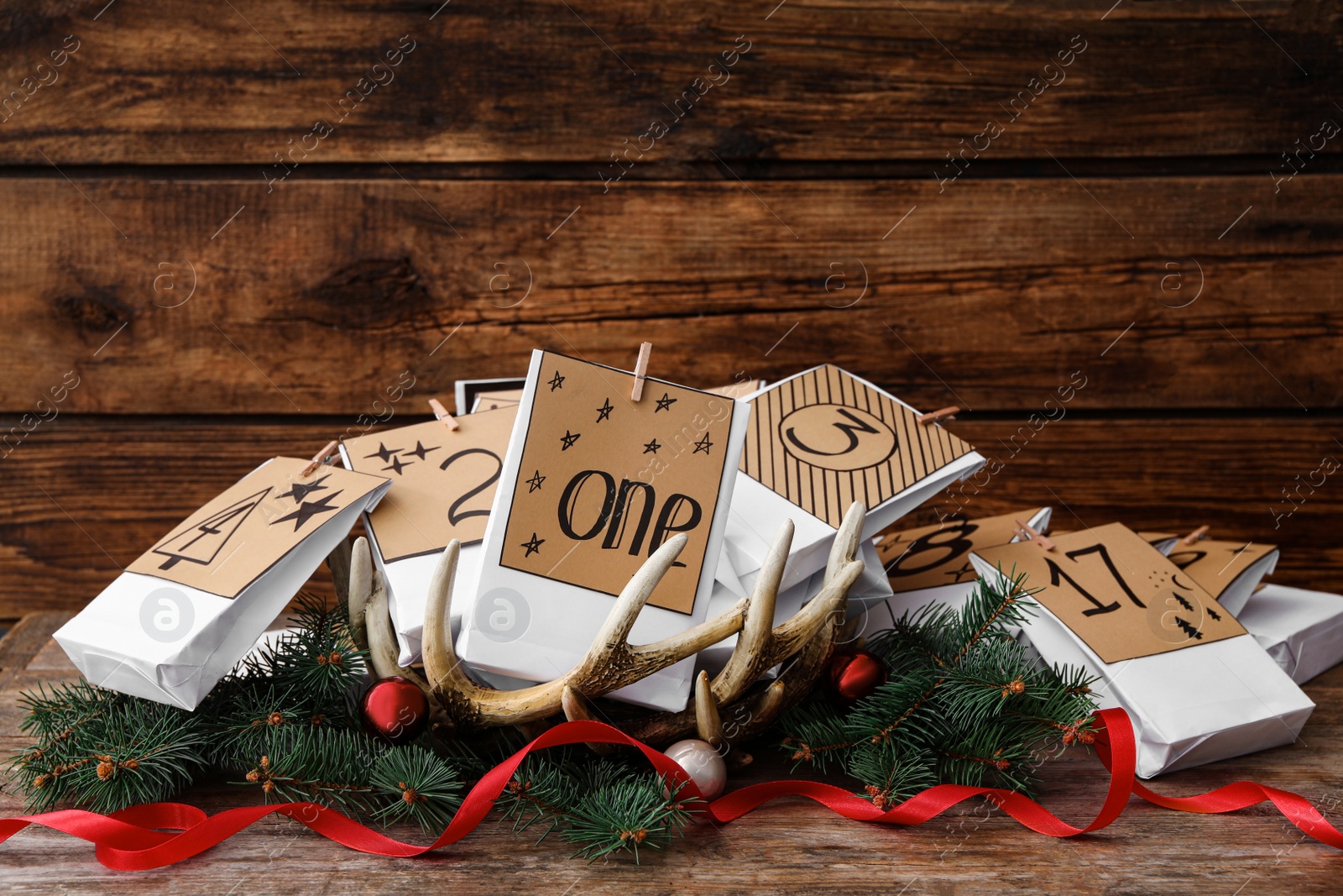 Photo of Paper bags and festive decor on wooden table. Christmas advent calendar