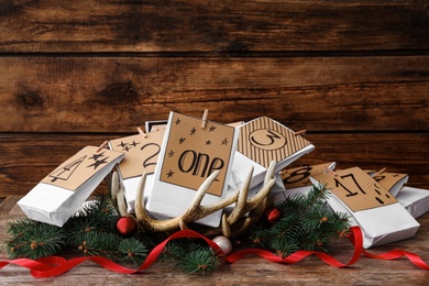 Paper bags and festive decor on wooden table. Christmas advent calendar