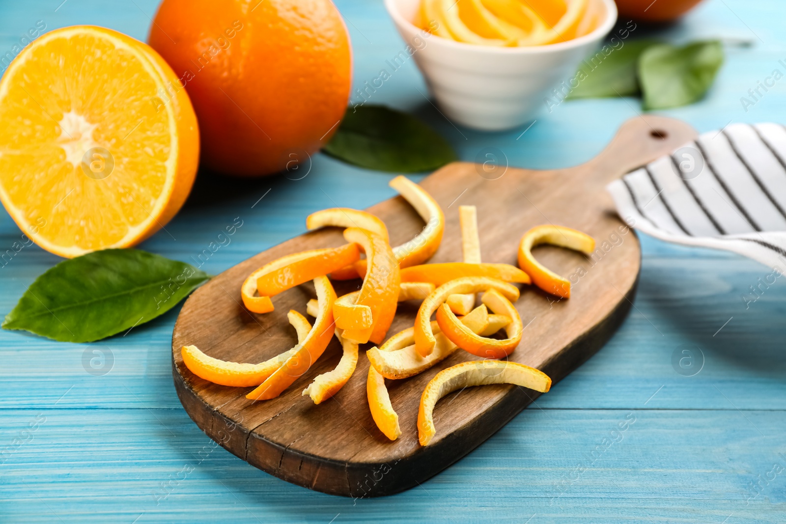 Photo of Orange peels on light blue wooden table