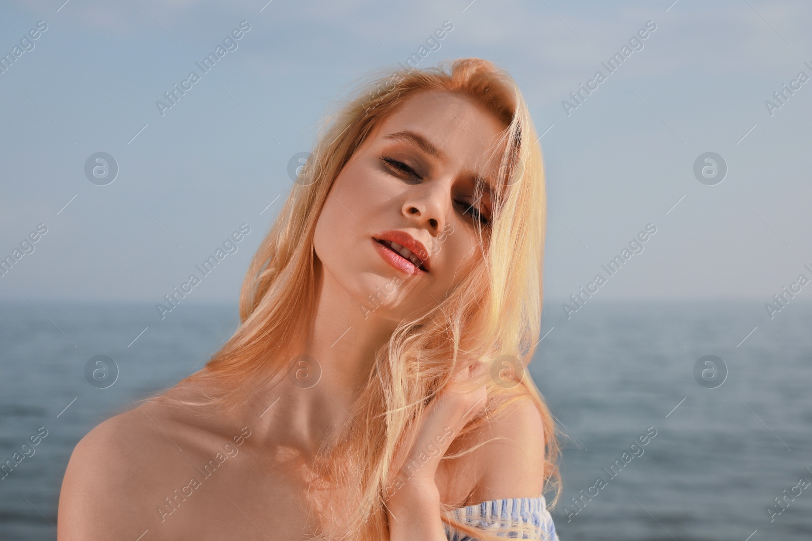 Photo of Beautiful young woman near sea on sunny day