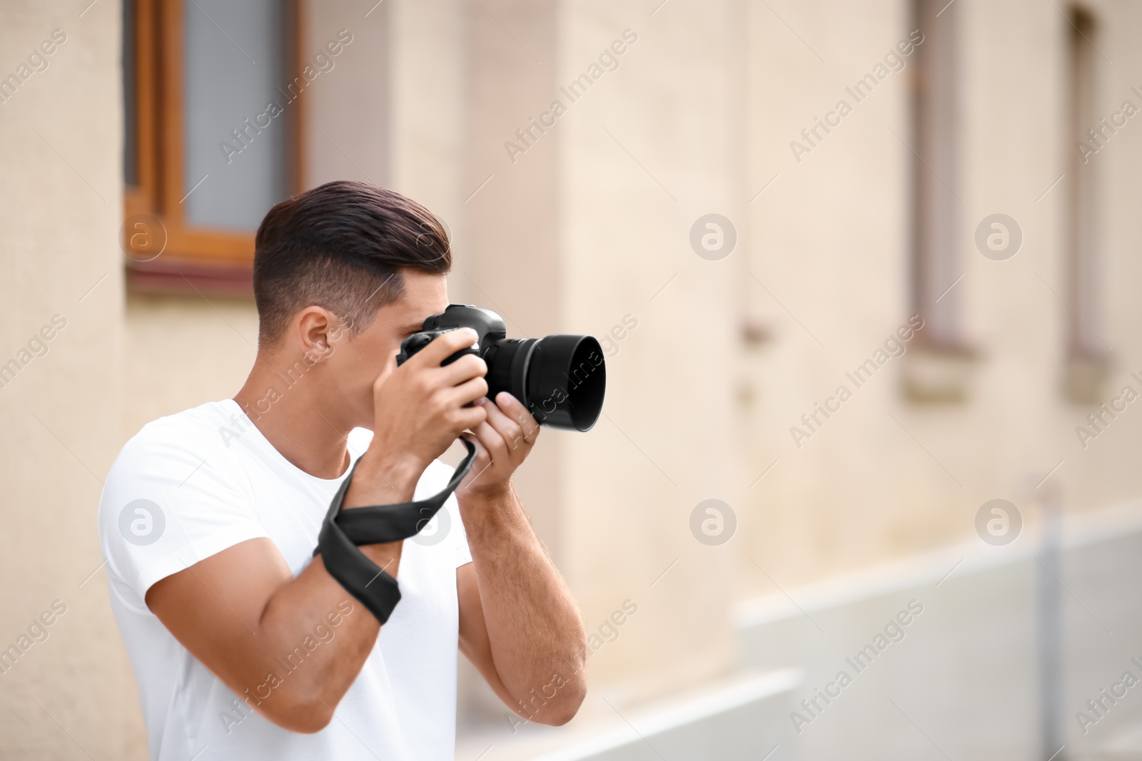 Photo of Photographer taking picture with professional camera on city street