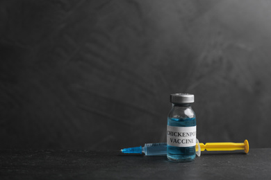 Chickenpox vaccine and syringe on grey background, space for text. Varicella virus prevention