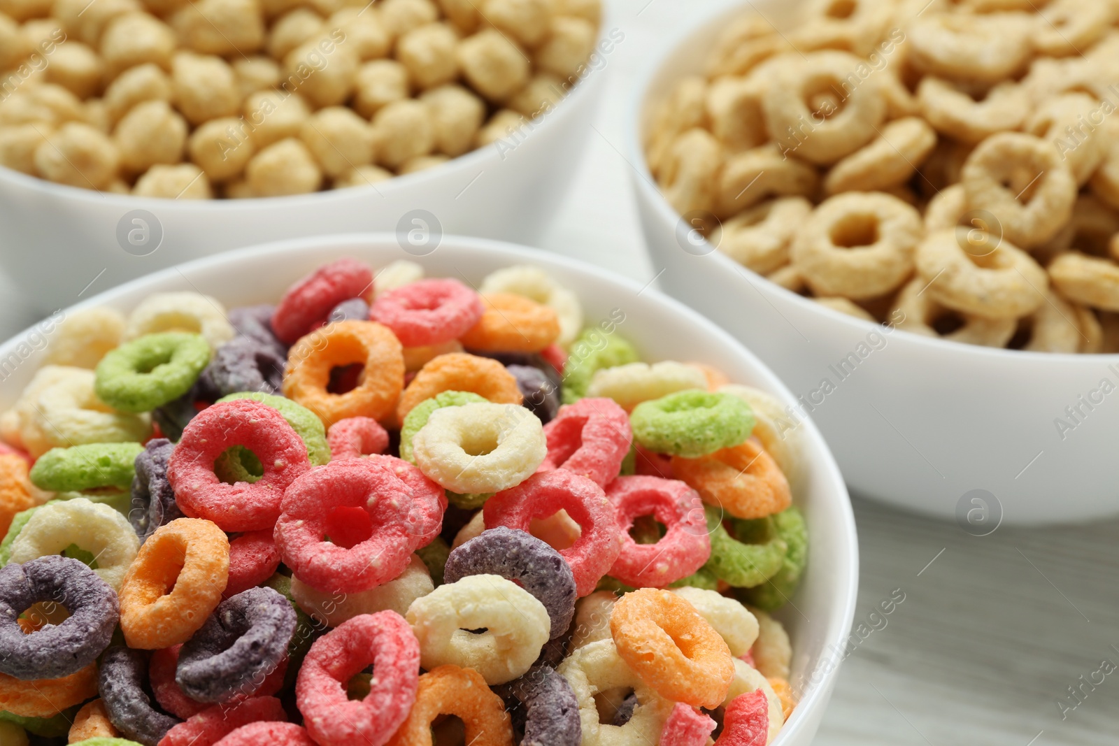 Photo of Different delicious breakfast cereals in bowls, closeup