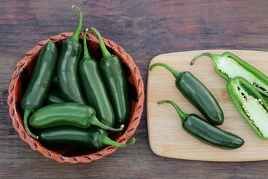 Photo of Whole and cut jalapeno peppers on wooden table, flat lay