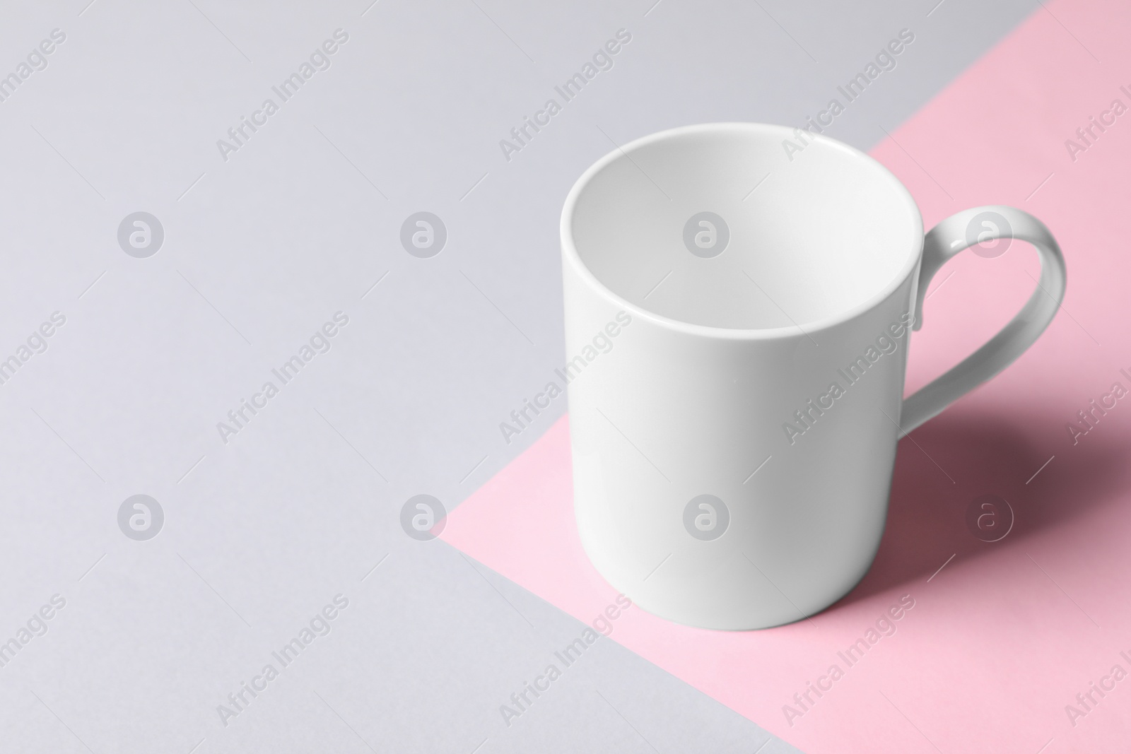 White ceramic mug on color background, space for text Photo of White ceramic mug on color background, space for text