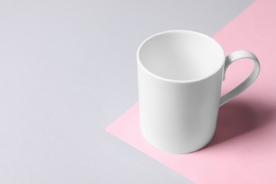 Photo of White ceramic mug on color background, space for text