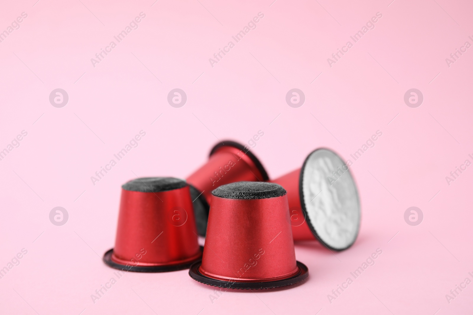 Photo of Many plastic coffee capsules on pink background, closeup