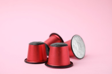 Many plastic coffee capsules on pink background, closeup