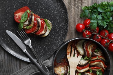 Delicious ratatouille served with basil on wooden table, flat lay