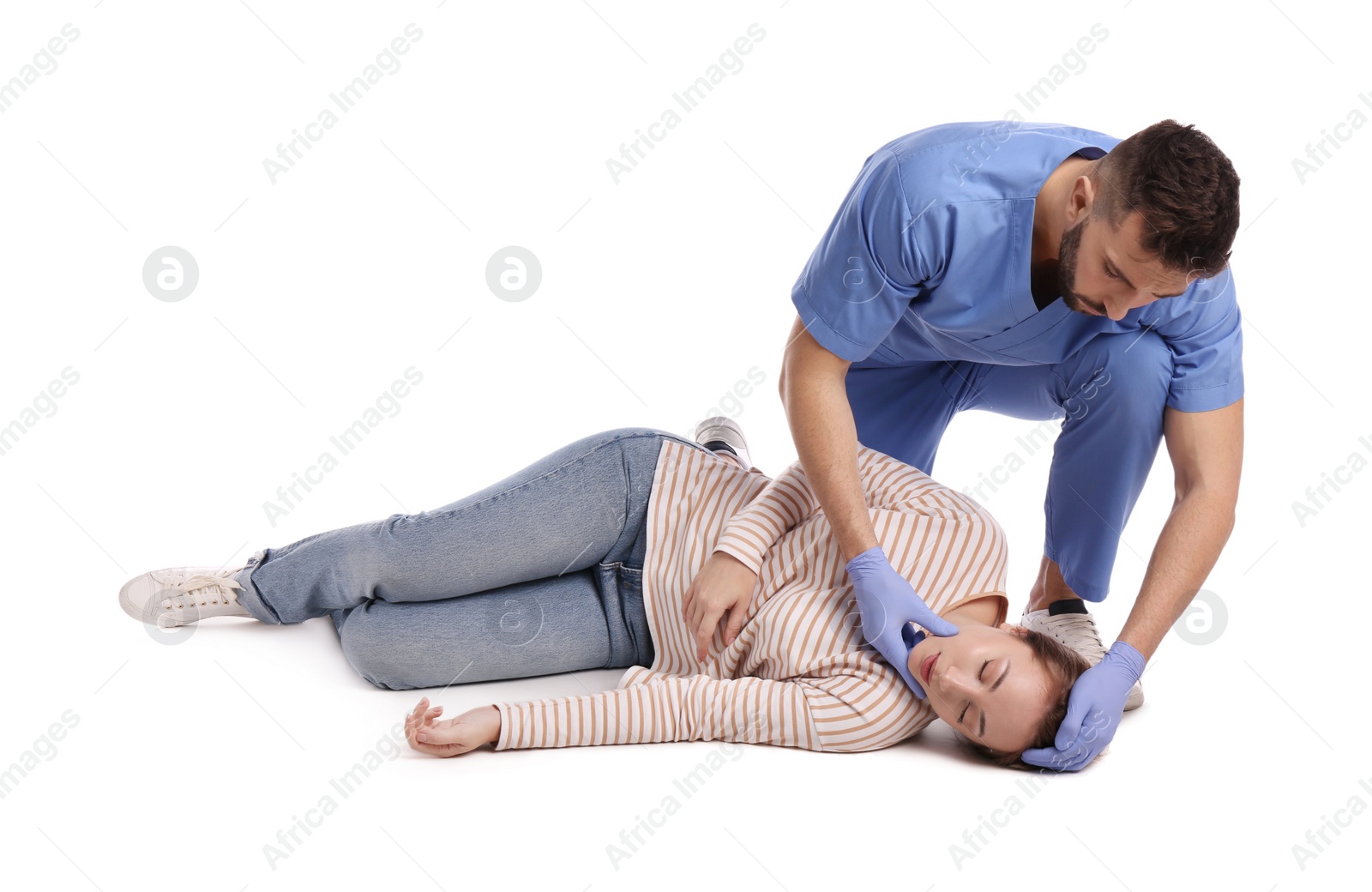 Photo of Doctor in uniform performing first aid on unconscious woman against white background