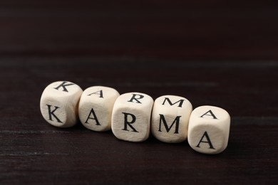 Photo of Word Karma made of cubes with letters on wooden table