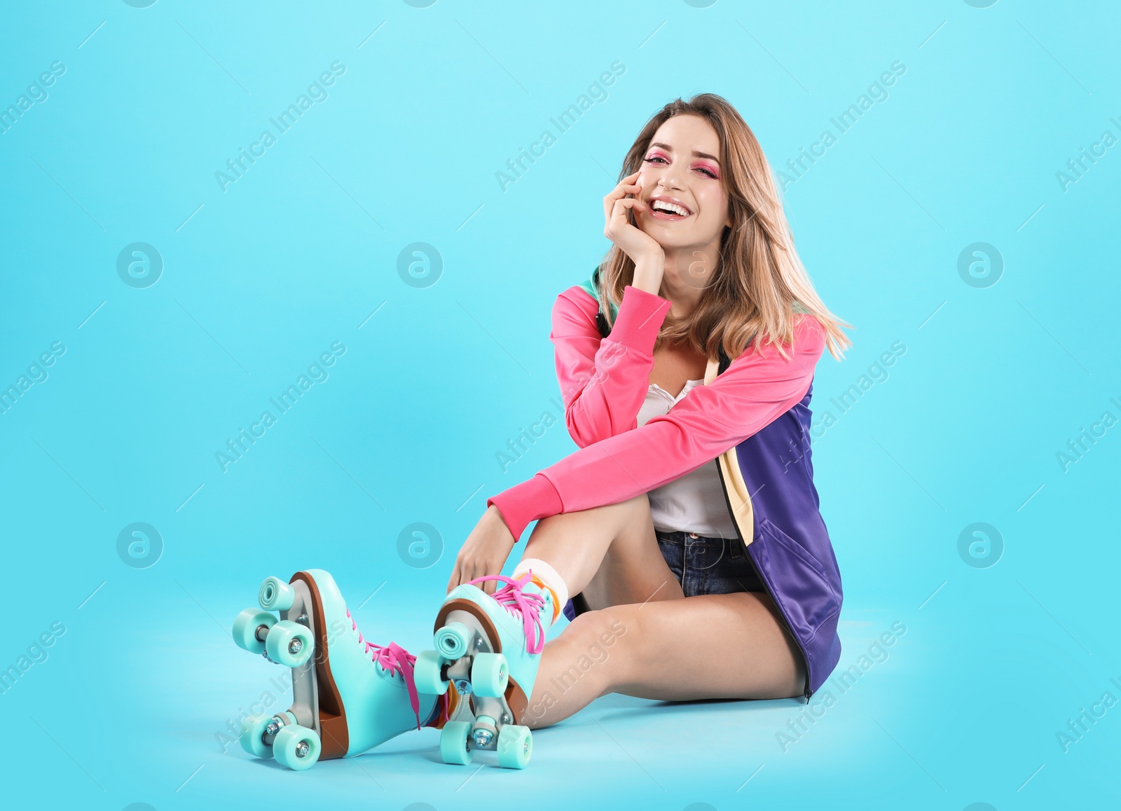 Photo of Young woman with retro roller skates on color background