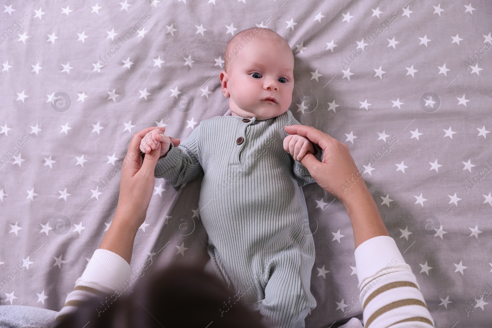 Photo of Mother and her little baby on bed, top view