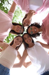 Photo of Happy women joined in circle outdoors, bottom view. Girl power concept