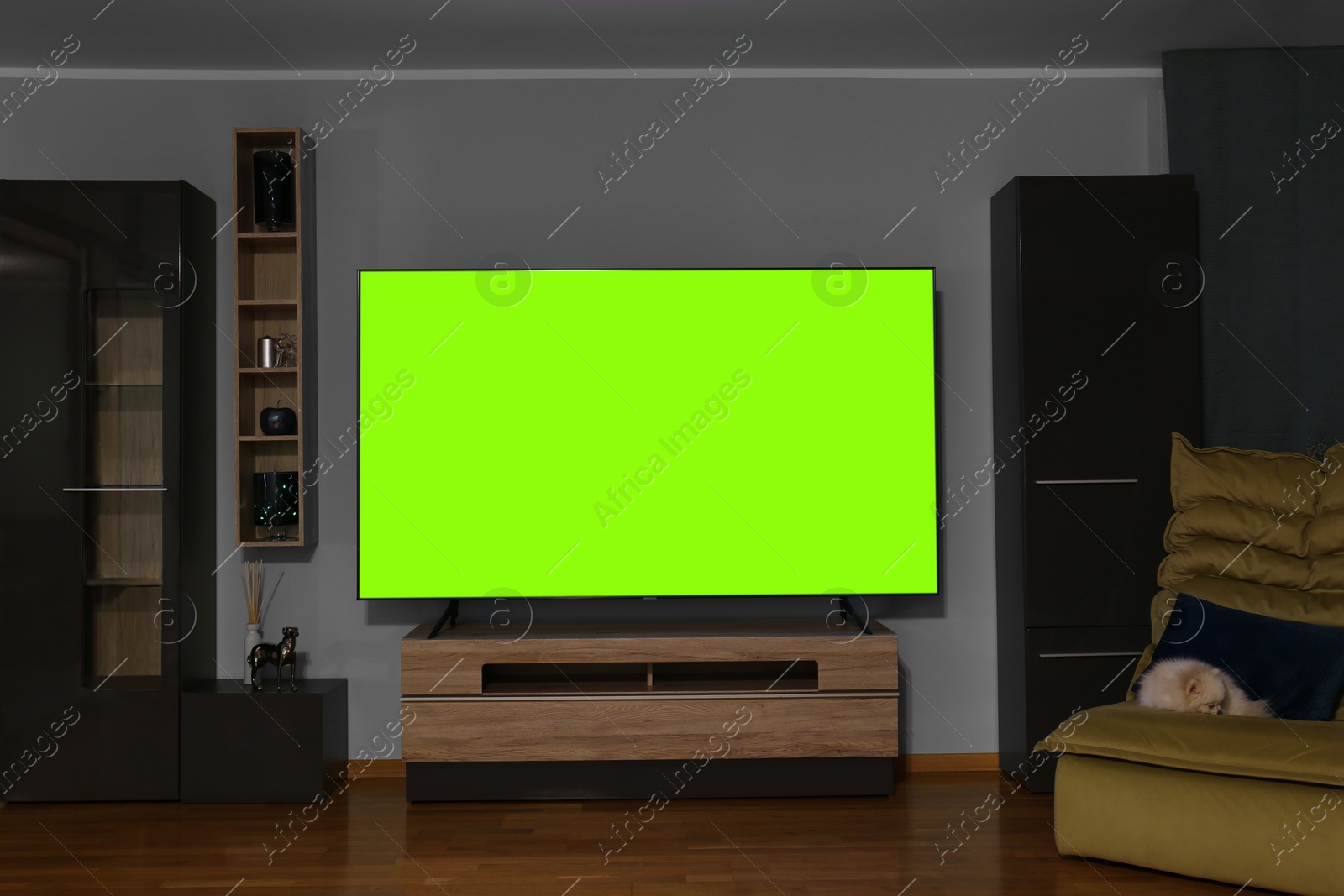 Photo of Modern plasma TV on wooden table and other furniture in living room